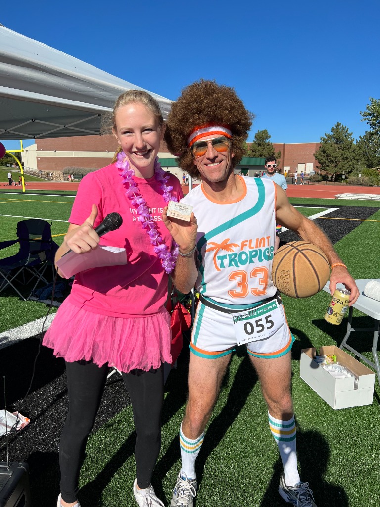 Race day costume winner holding trophy card
